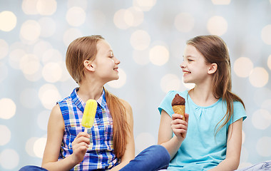 Image showing happy little girls eating ice-cream over lights