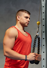 Image showing man flexing muscles on cable machine gym