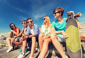 Image showing group of smiling friends sitting on city street