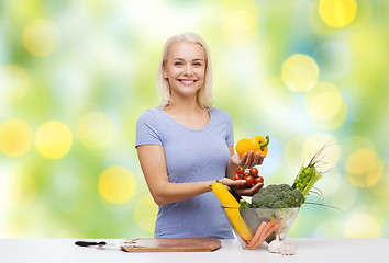 Image showing smiling young woman cooking vegetables at home