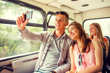 Image showing smiling couple with smartphone making selfie