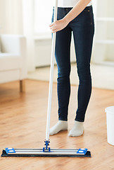 Image showing close up of woman with mop cleaning floor at home