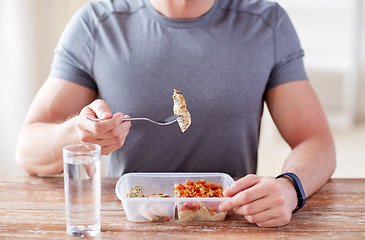 Image showing close up of man with fork and water eating food