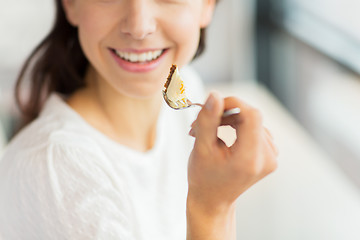 Image showing close up of woman eating cake at cafe or home