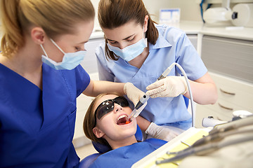 Image showing female dentists treating patient girl teeth