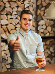 Image showing happy man with beer showing thumbs up at bar