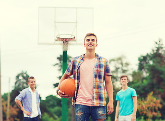 Image showing group of smiling teenagers playing basketball