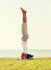 Image showing man making yoga exercises outdoors