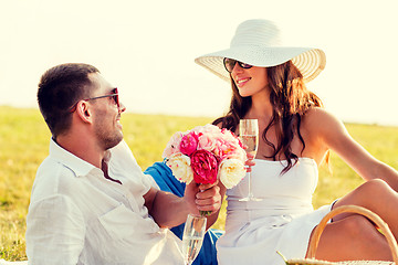 Image showing smiling couple drinking champagne on picnic