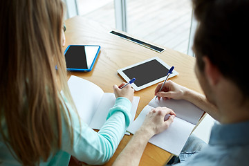 Image showing students with tablet pc writing to notebooks