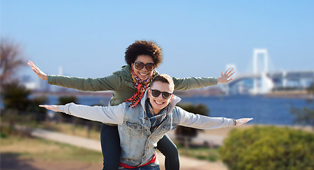 Image showing happy teenage couple in shades having fun outdoors