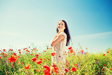 Image showing smiling young woman on poppy field