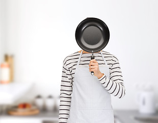 Image showing man or cook in apron hiding face behind frying pan