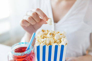 Image showing woman eating popcorn with drink in glass mason jar