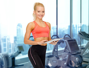 Image showing smiling sporty woman with tablet pc in gym