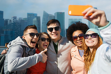 Image showing smiling friends taking selfie with smartphone