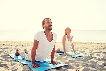 Image showing couple making yoga exercises outdoors