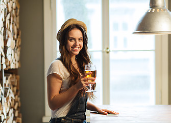 Image showing happy young woman drinking beer at bar or pub