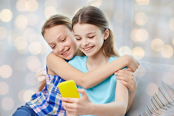 Image showing happy girls with smartphone taking selfie at home