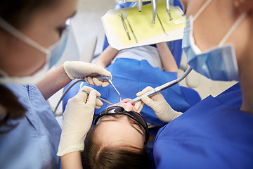 Image showing female dentists treating patient girl teeth