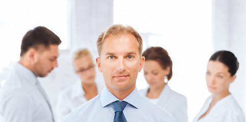Image showing businessman in office with group on the back