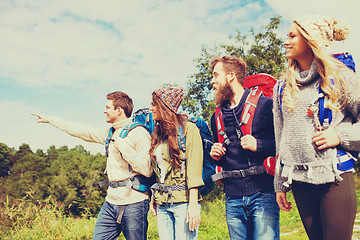 Image showing group of smiling friends with backpacks hiking