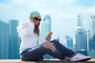 Image showing happy young woman with smartphone and headphones