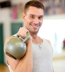 Image showing smiling man with kettlebell in gym