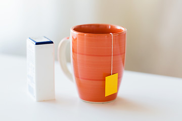 Image showing close up of sweetener and tea cup on table