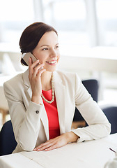 Image showing happy woman calling on smart phone at restaurant