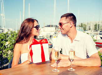 Image showing smiling couple with gift box cafe