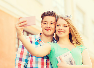 Image showing smiling couple with smartphone in city