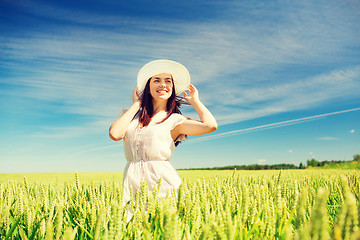 Image showing smiling young woman in straw hat on cereal field