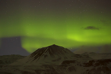 Image showing Northern lights with snowy mountains in the foreground