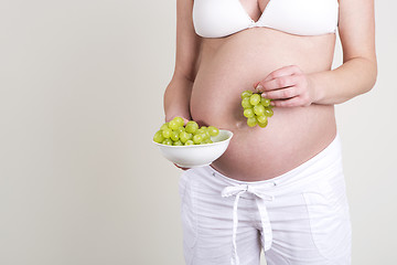 Image showing Pregnant woman with a bowl of grapes in her hands