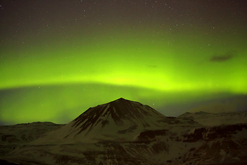 Image showing Northern lights with snowy mountains in the foreground