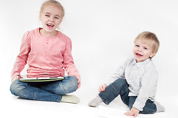 Image showing Happy girl uses tablet and boy playing with chalk