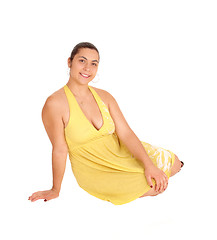 Image showing Young woman sitting in yellow dress.