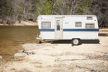 Image showing Classic Old Camper Trailer Near A River