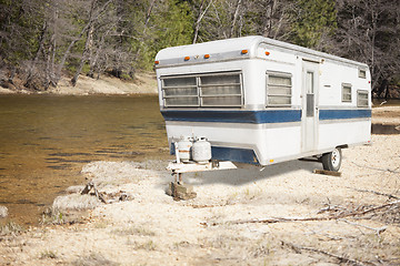 Image showing Classic Old Camper Trailer Near A River