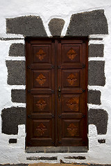 Image showing brass brown knocker in a brown closed woo