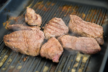 Image showing cooking steaks on a hot grill