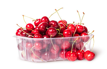 Image showing Red sweet cherries in plastic tray rotated and three near