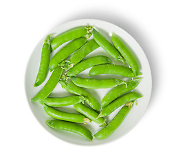 Image showing Several pods of peas on a white plate top view