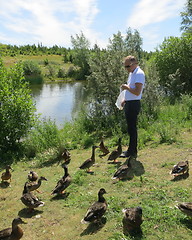 Image showing Man feeding ducks