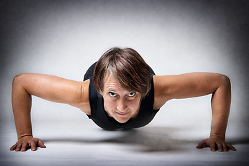 Image showing Middle aged woman doing push-ups
