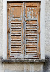 Image showing Closed window of the old building covered by wooden blinds with peeling paint