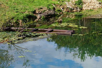 Image showing Sunken old wooden boat in summer river