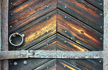 Image showing Very old weather beaten door in brownish colours.