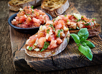 Image showing bruschettas ingredients on wooden cutting board